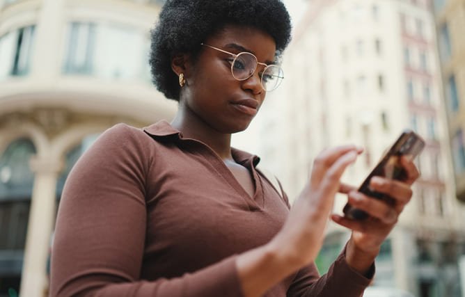 A person using a smartphone, representing the idea of receiving personalized SMS marketing messages.